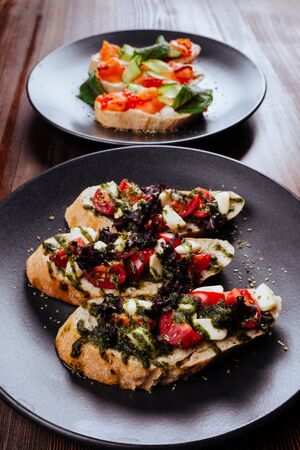 Italian Appetizer Bruschetta with roasted tomatoes, mozzarella cheese, garlic and herbsの写真素材