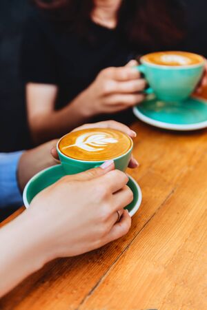 two beautiful woman keeping cups of coffee.の写真素材