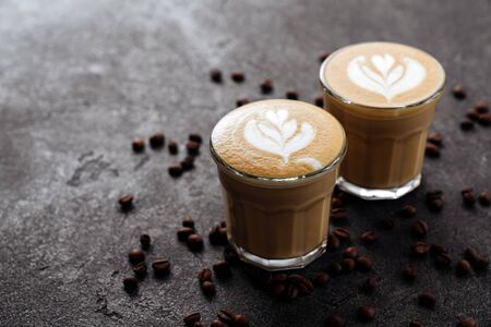 two cups of coffee on black stone background