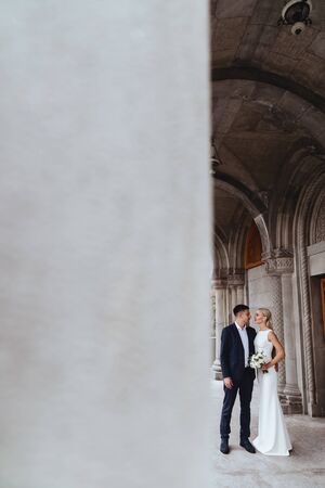 Happy bride and groom near old castle