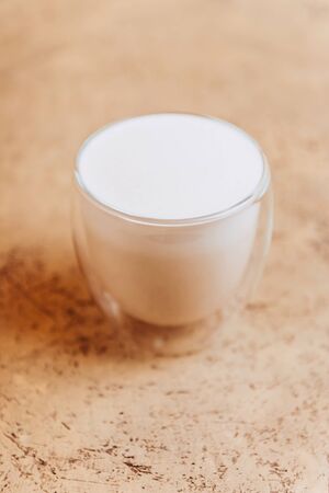 Glass tasty fresh cup of coffee latte on light tableの写真素材