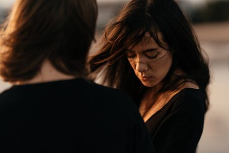 Attractive man and woman enjoying romantic evening on sunsetの写真素材