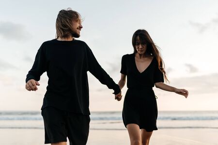 Attractive man and woman enjoying romantic evening on sunsetの写真素材