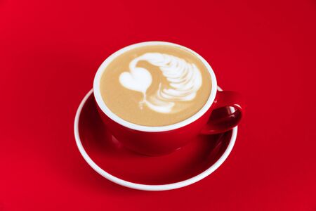 Hot cappuccino on red table with selective focus on the latte artの写真素材