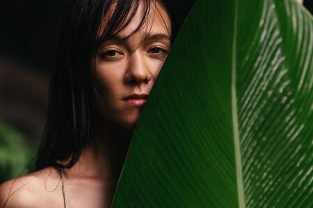 portrait of woman on green leafs back
