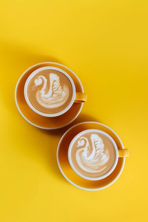 Coffee latte art on yellow backgroundの写真素材