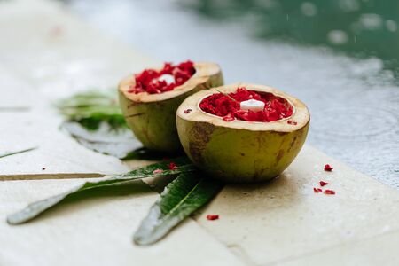 Rose blossom, Petals in coconut bowl, red flowers, candlesの写真素材