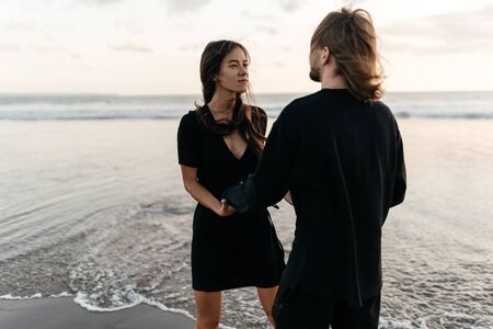 Attractive man and woman enjoying romantic evening on sunset