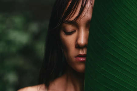 portrait of woman on green leafs back