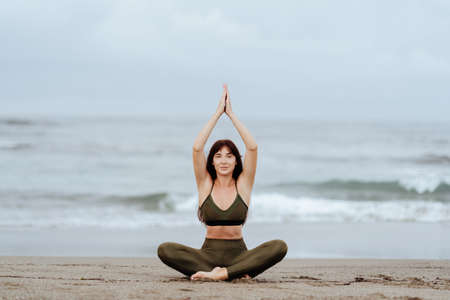 woman doing yoga exercises on the beachの写真素材