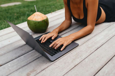 Woman freelance work typing on laptop with fresh coconut .
