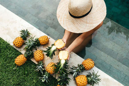 Beautiful Woman Relaxing In Swimming Pool With Pineapples. Healthy Lifestyle, Nutrition, Diet....