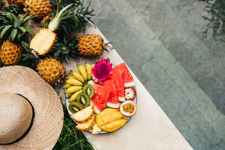Still life image of tropical fruits and flowers near the poolの写真素材