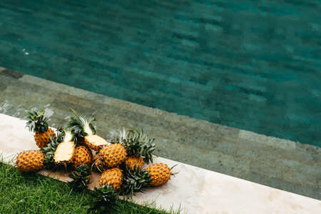 Healthy Raw Organic Food. Fresh Ripe Pineapples near Pure Water In Swimming Pool.の写真素材