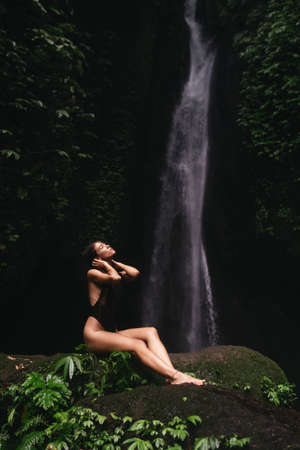 young woman looking at the waterfall in jungles.の写真素材