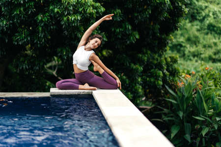 Woman practicing yoga performing yoga-asanas outdoors.の写真素材