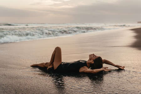 woman on beach is enjoying serene ocean nature during travel holidays vacation outdoorsの写真素材