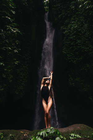 young woman backpacker looking at the waterfall in jungles.の写真素材