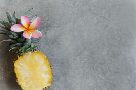 Pineapple and frangipania on a stone table. Tropical Fruits.の写真素材
