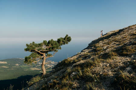 Attractive young loving couple of man and woman in the green mountain landscape