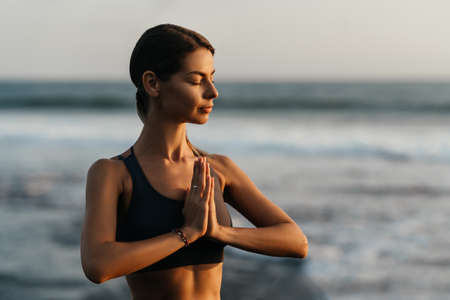 young beautiful woman meditation on beach.