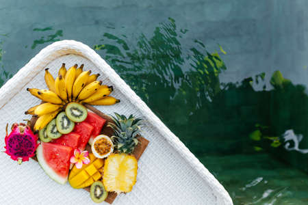 Still life image of tropical fruits and flowers near the poolの写真素材