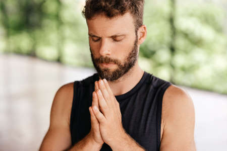 Yoga men workout in studio in front of a windowの写真素材