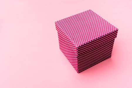 Gift box on paste pink background.