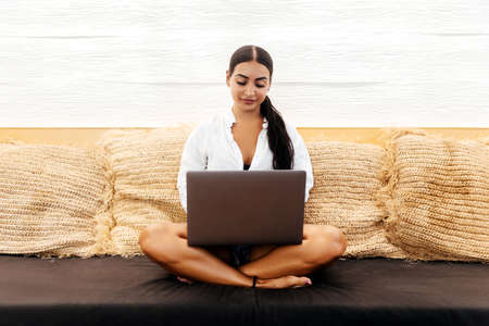Young female with portable net-book in modern coffee shop during recreation time.の写真素材