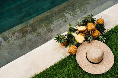 Delicious ripe pineapples with hat by the pool. Bali Indonesia.の写真素材