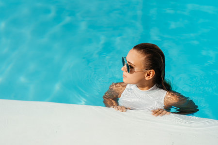 Young woman relaxing in swimming pool on summer vacation.