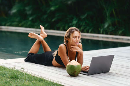 Woman freelance work typing on laptop with fresh coconut .の写真素材