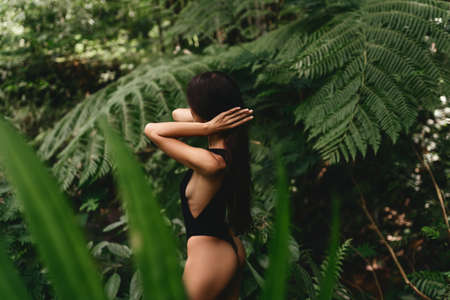 Attractive young woman among the tropical plants.の写真素材