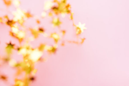 Golden star sprinkles on pink. Festive holiday background. Celebration concept. Top view, flat lay. Horizontalの写真素材