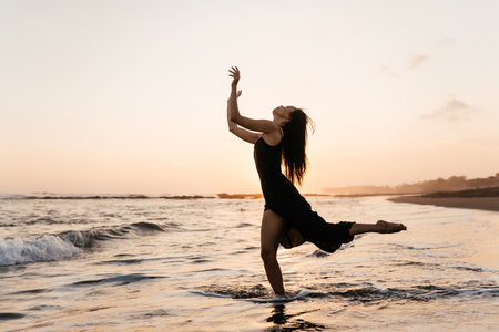 Freedom Chinese woman feeling free dancing at beach sunset.