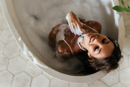 Relaxed young woman laying in bathtubの写真素材