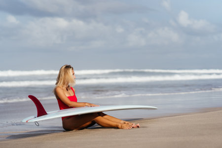Surf woman with long blonde hair go to ocean.の写真素材