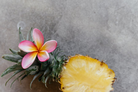 Pineapple and frangipania on a stone table. Tropical Fruits.