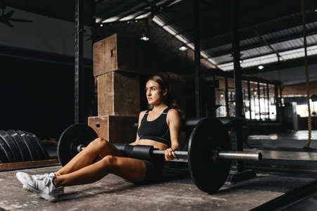 Fit young woman at a crossfit style on dark gray background.の写真素材