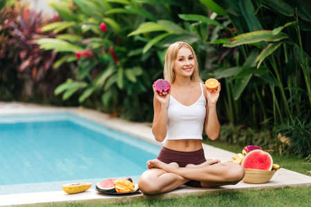 Woman relaxing and eating fruits in the pool on luxury villa in Bali.の写真素材