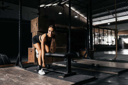 Fit young woman at a crossfit style on dark gray background.の写真素材