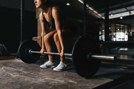 Fit young woman at a crossfit style on dark gray background.の写真素材
