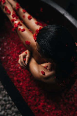 Beautiful female in bath with rose petal. Body care.の写真素材