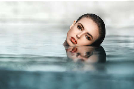 Young pretty fashion woman posing outdoor in summer in bikini on poolの写真素材