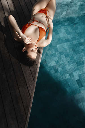 Young pretty fashion woman posing outdoor in summer in bikini on poolの写真素材