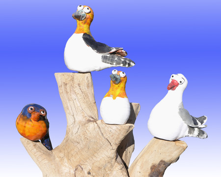 Four china model birds on a log      の写真素材