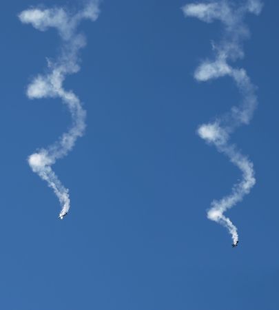 Synchronous Aerobatic aircraft in a spin with smoke trails       