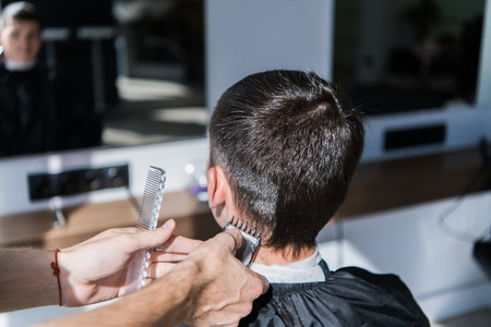 Young man having a haircut with a hair clippers.の写真素材