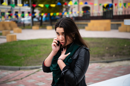 Woman with serious expression talking on telephone.の写真素材