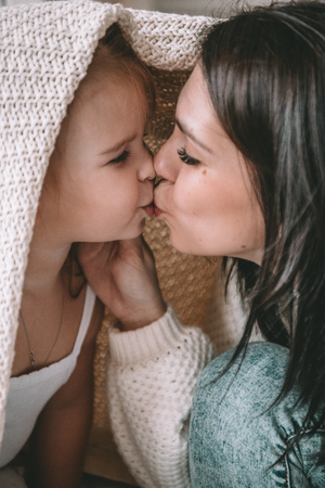 Beautiful young woman with her daughter showing love and affectionの写真素材